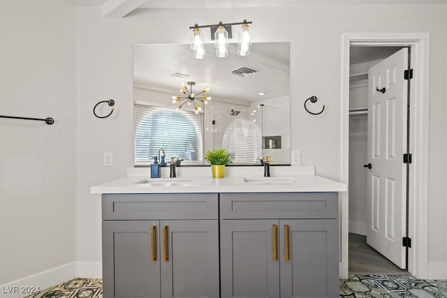 bathroom featuring double vanity, a stall shower, visible vents, and a sink