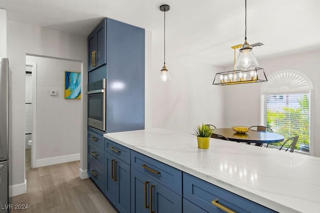 kitchen with light stone counters, light wood-type flooring, stainless steel oven, and blue cabinetry