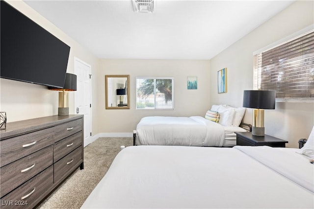 bedroom with light carpet, visible vents, and baseboards