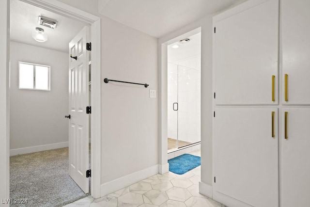 hallway with visible vents and baseboards