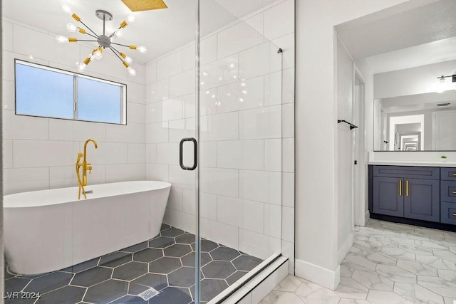 bathroom featuring marble finish floor, a freestanding bath, vanity, a shower stall, and a notable chandelier