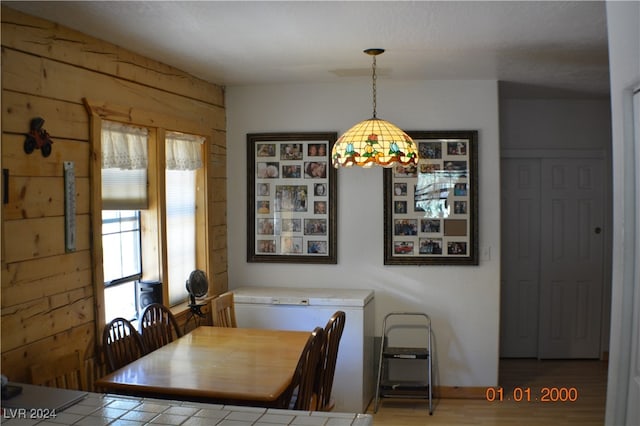 dining area featuring wooden walls and hardwood / wood-style flooring