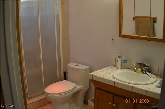 bathroom with tile patterned flooring, a shower with door, toilet, and vanity