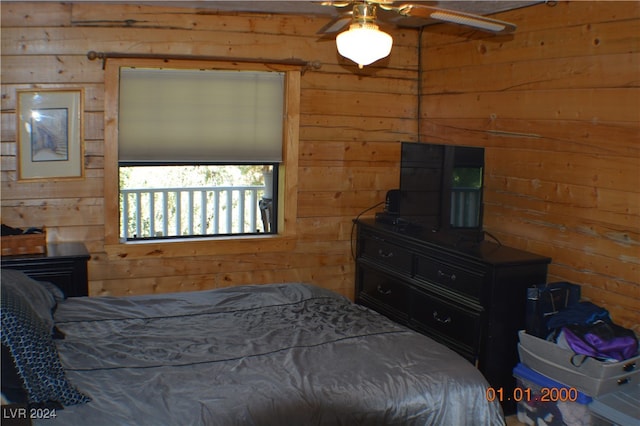 bedroom with wooden walls and ceiling fan