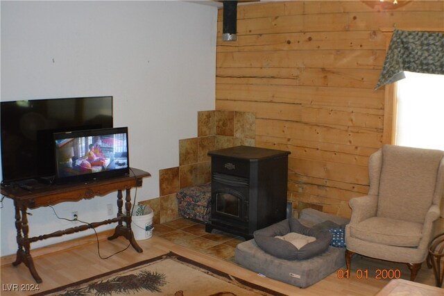 living room with a wood stove and wood-type flooring