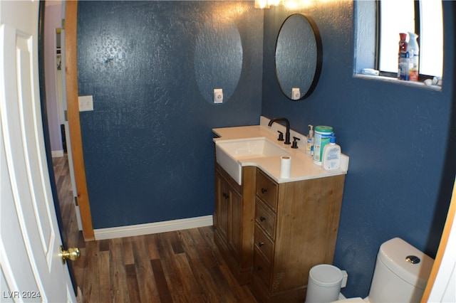 bathroom with vanity, wood-type flooring, and toilet