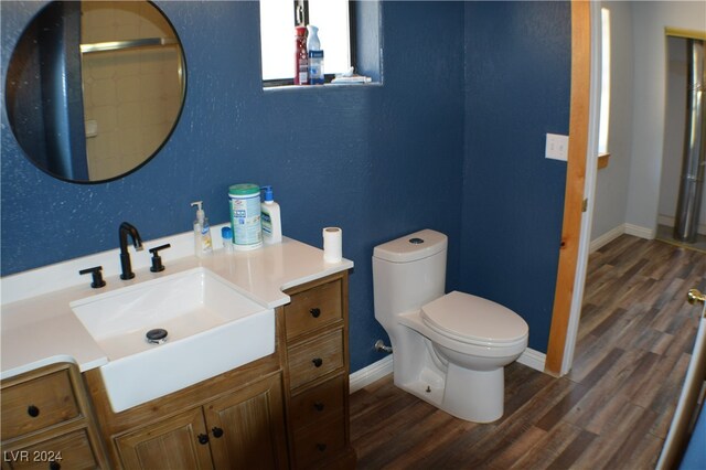 bathroom with wood-type flooring, toilet, and vanity