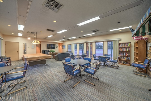 recreation room with carpet floors and a textured ceiling