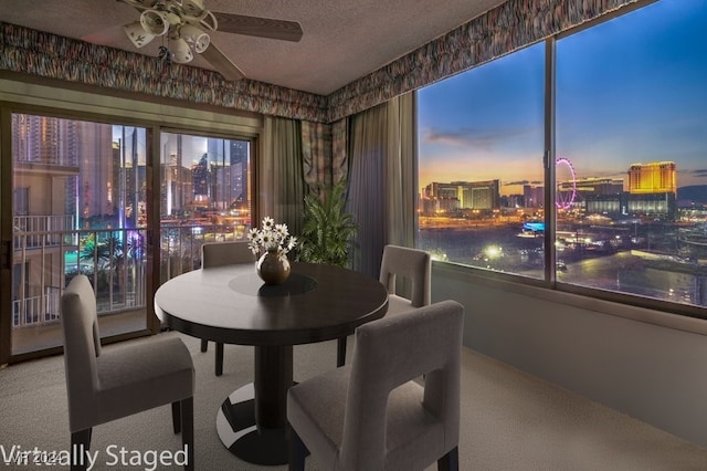 dining area with ceiling fan, a textured ceiling, and carpet flooring