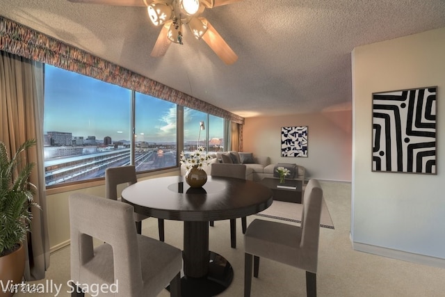 dining space featuring a textured ceiling, carpet, and ceiling fan