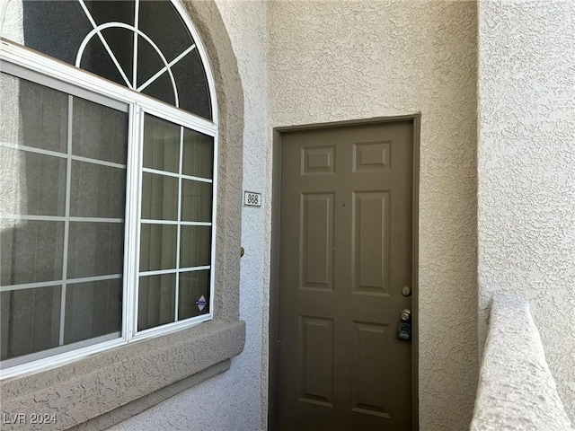 entrance to property featuring stucco siding