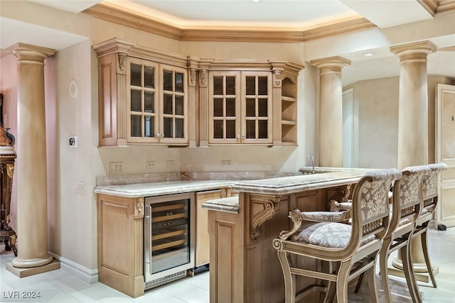 bar with light tile patterned floors, ornamental molding, wine cooler, and ornate columns