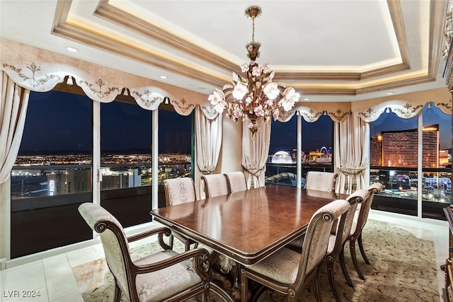 dining room featuring crown molding, a raised ceiling, and a notable chandelier