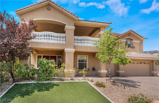 view of front of home with a front lawn, a balcony, and a garage