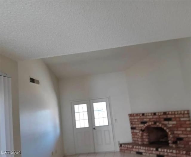 room details with a fireplace, a textured ceiling, and tile patterned flooring