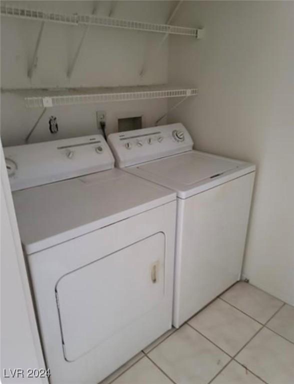 laundry area featuring washing machine and dryer and light tile patterned floors