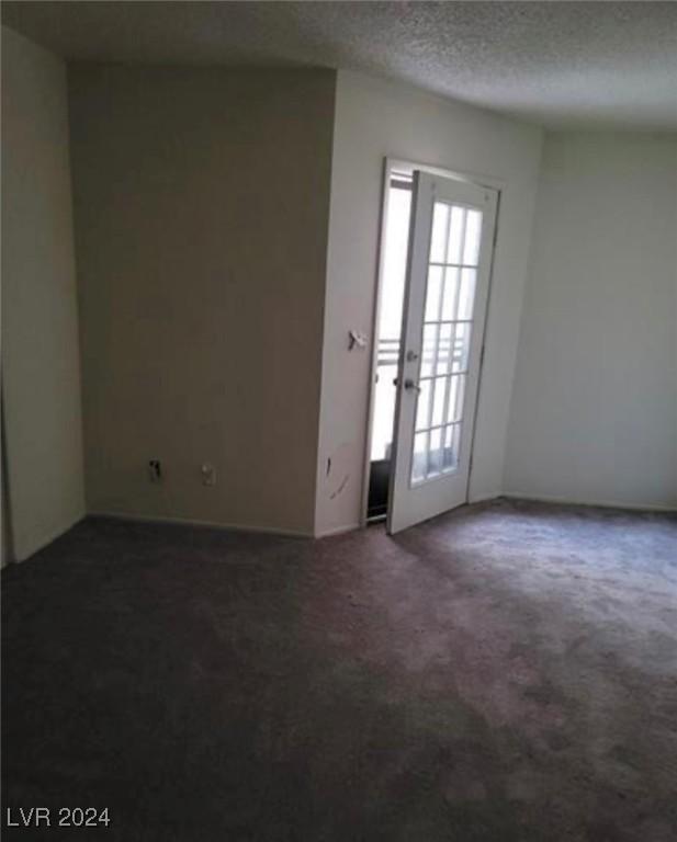 foyer featuring carpet floors, a textured ceiling, and french doors