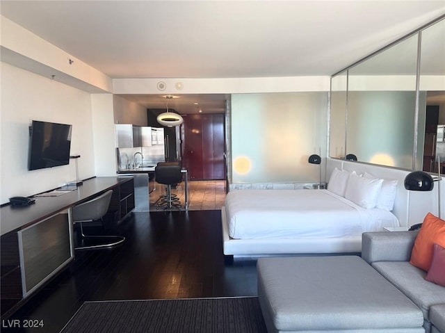 bedroom with a sink and wood finished floors