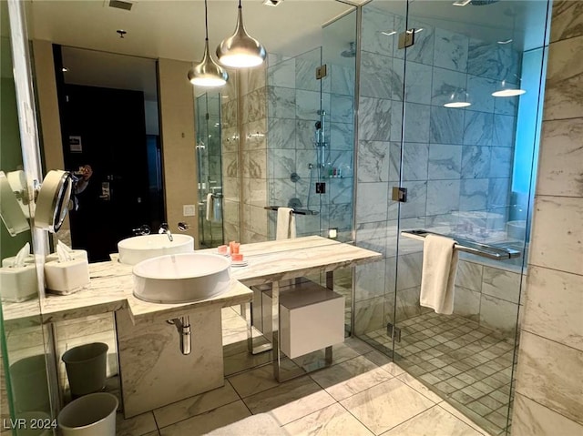 bathroom with a stall shower, marble finish floor, and double sink