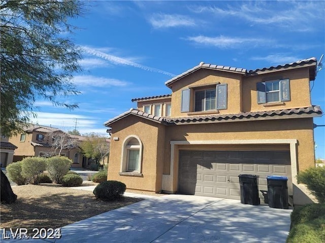 mediterranean / spanish-style house with concrete driveway, an attached garage, a tiled roof, and stucco siding