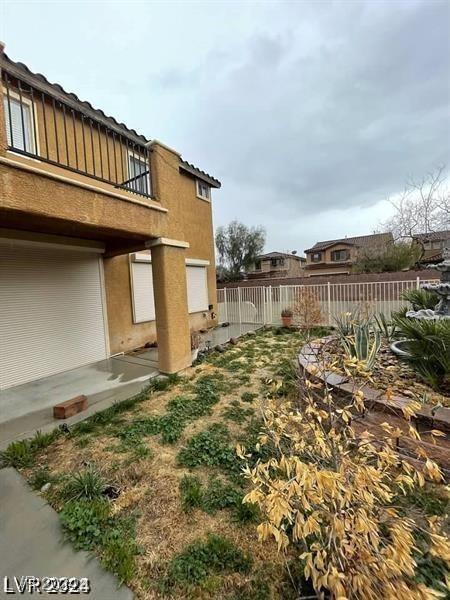 view of yard with fence and a balcony