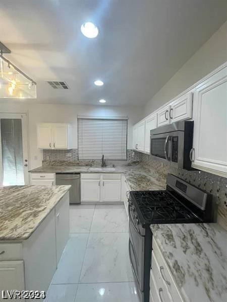 kitchen featuring a sink, visible vents, white cabinets, marble finish floor, and appliances with stainless steel finishes