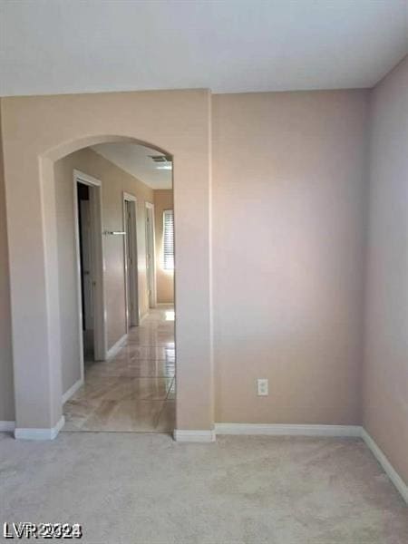 unfurnished room with arched walkways and baseboards