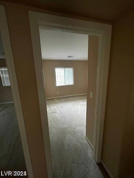 hallway with carpet flooring and baseboards