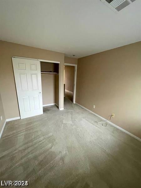 unfurnished bedroom with baseboards, visible vents, and a closet