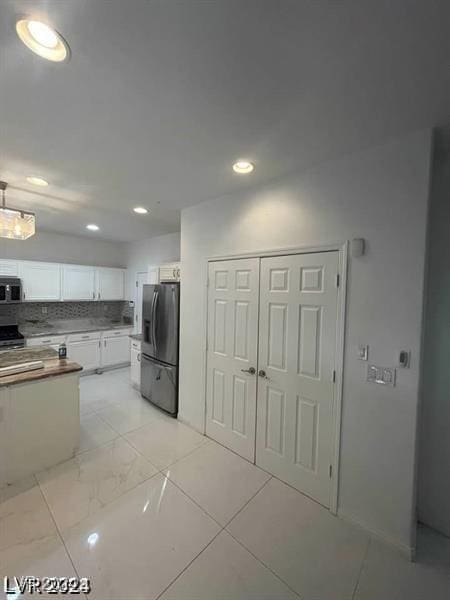 kitchen featuring tasteful backsplash, appliances with stainless steel finishes, marble finish floor, white cabinetry, and recessed lighting