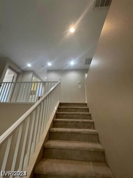 staircase featuring visible vents and recessed lighting