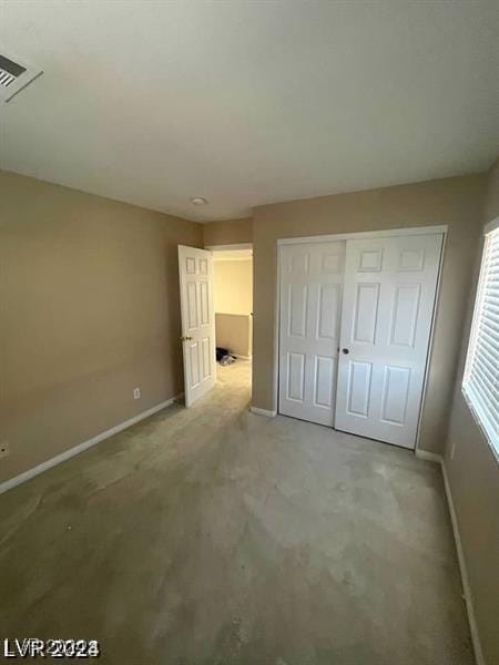 unfurnished bedroom featuring baseboards and a closet