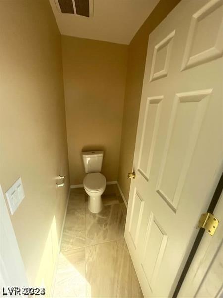 bathroom featuring baseboards and toilet