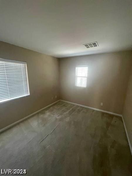 carpeted empty room with baseboards and visible vents