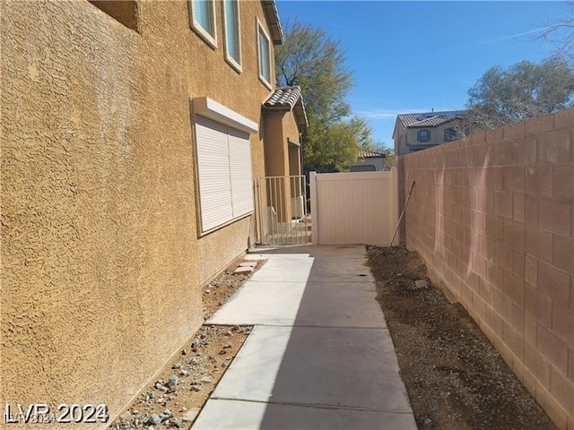 view of side of property featuring fence and stucco siding