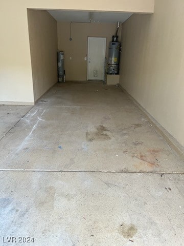 garage with strapped water heater and water heater