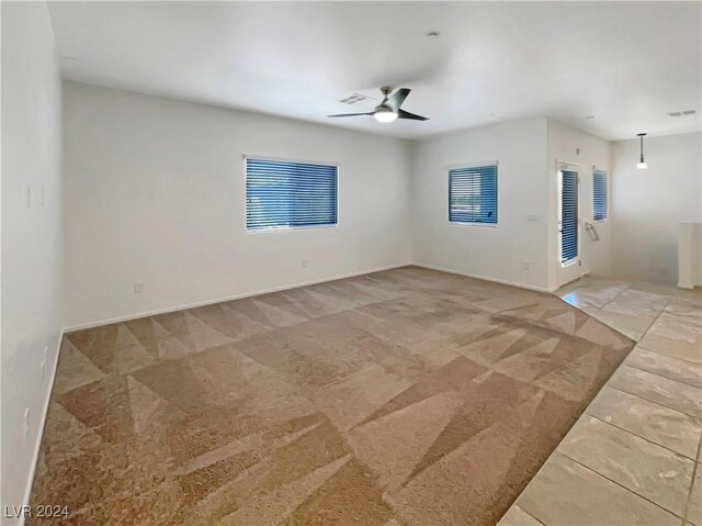 carpeted empty room featuring ceiling fan