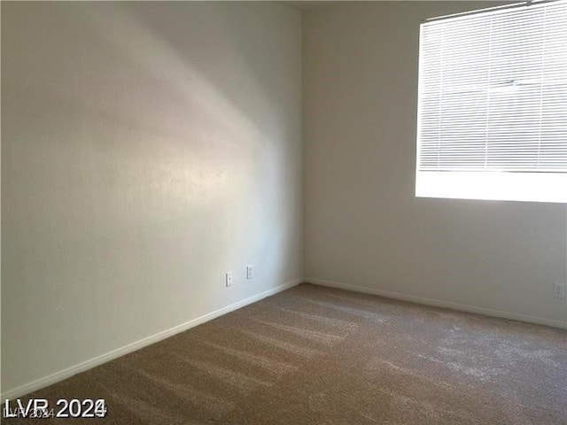 spare room featuring baseboards and carpet flooring