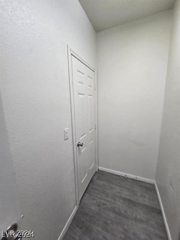 interior space featuring dark wood-type flooring and baseboards