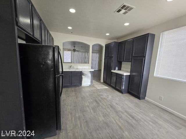 kitchen with visible vents, arched walkways, light countertops, and freestanding refrigerator