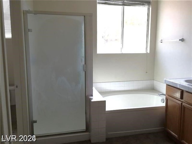 bathroom featuring vanity, a bath, and a shower stall