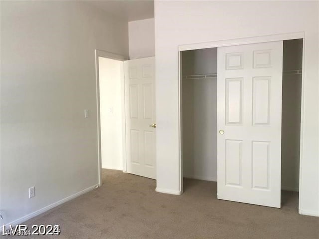 unfurnished bedroom with a closet, baseboards, and carpet flooring