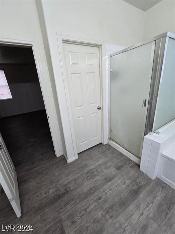 interior space with a garden tub, wood finished floors, and a stall shower