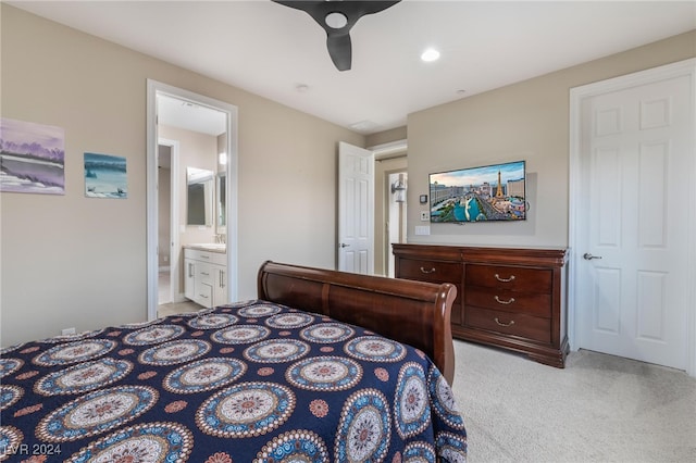 carpeted bedroom featuring ensuite bath, ceiling fan, and sink