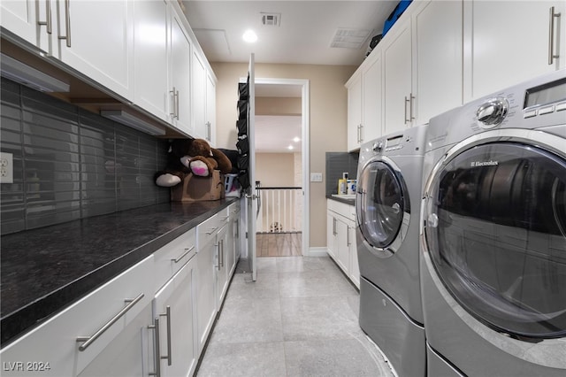 laundry room featuring washing machine and dryer and cabinets