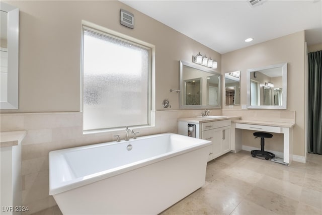 bathroom with a bath, tile walls, and vanity