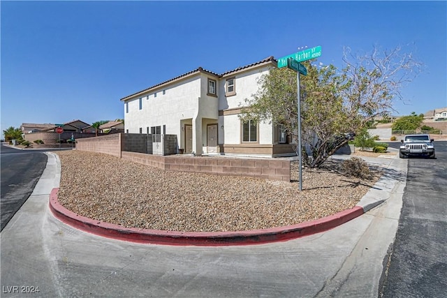 exterior space featuring a tile roof, fence, and stucco siding