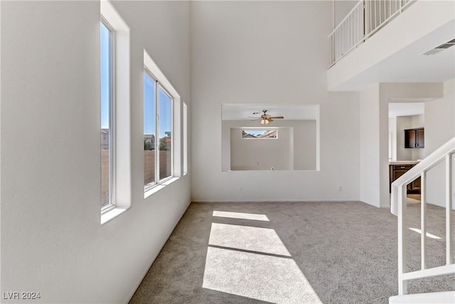 interior space with a towering ceiling, stairway, and visible vents