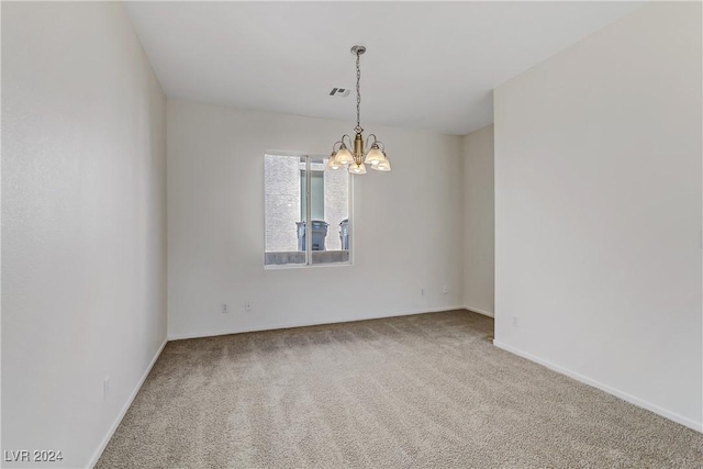 carpeted empty room with a chandelier, visible vents, and baseboards