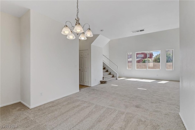 carpeted spare room featuring a chandelier, visible vents, stairway, and baseboards